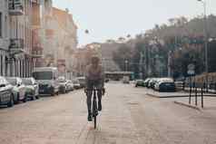 男人。体育运动衣服骑黑色的自行车城市街