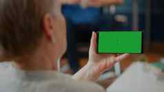 退休成人持有智能手机水平绿色屏幕