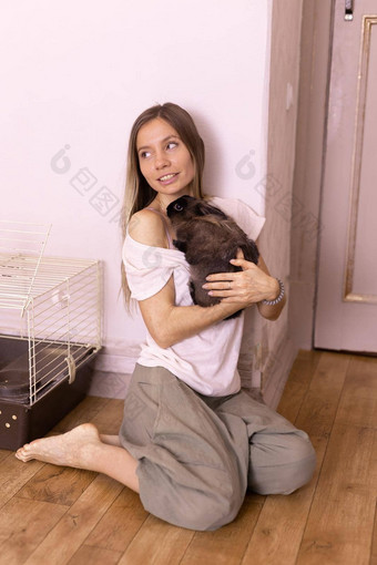 年轻的女人可爱的兔子在室内关闭可爱的宠物动物概念