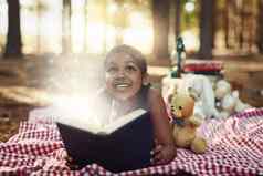 阅读神奇的美妙的世界拍摄女孩阅读书发光的页面森林