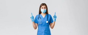 科维德防止病毒健康医疗保健工人概念惊讶好奇的女护士蓝色的实习医生风云个人保护设备指出手指发现有趣的新闻