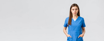 医疗保健工人防止病毒保险医学概念严肃的表情自信年轻的医疗工人护士医生蓝色的实习医生风云持有手口袋相机