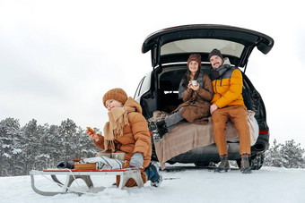 冬天肖像家庭坐车树干享受假期森林