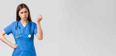 医疗工人医疗保健科维德疫苗接种概念愤怒的脾气暴躁的年轻的女护士医生责骂年轻的病人打破检疫规则摇晃拳头威胁