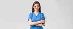 医疗保健工人医学保险科维德流感大流行概念自信热情的年轻的女护士医生蓝色的实习医生风云眼镜持有听诊器微笑相机很高兴