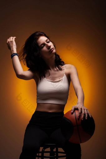 十几岁的女孩<strong>篮球</strong>工作室肖像橙色彩色的背景