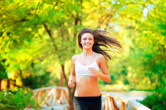燃烧小道卡路里拍摄positive-looking年轻的女人慢跑公园秋天