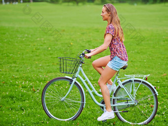 采取骑农村拍摄年轻的女人骑自行车农村