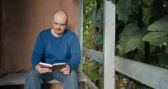 男人。阅读纸书坐着玄关村房子