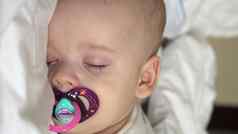 垂直特写镜头脸新生儿胖乎乎的睡觉婴儿说谎胃开放眼睛微笑覆盖毯子床上白色背景婴儿期童年发展医学健康概念