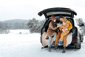 冬天肖像家庭坐车树干享受假期森林