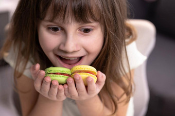 有吸引力的微笑可爱的学校孩子女孩持有美味的饼干手传统的法国五彩缤纷的蛋白杏仁饼干食物概念