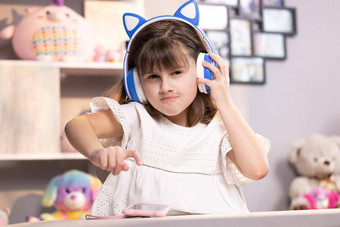 小孩子女孩耳机有趣的编辑应用程序智能手机享受很酷的视频音乐内容社会网络玩在线游戏沟通距离的远近
