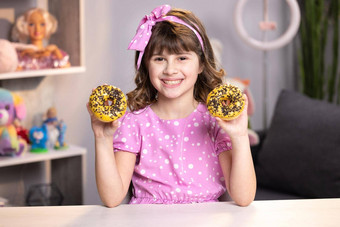 肖像甜蜜的女孩选择甜甜圈首页房间快乐的学校女孩玩蛋糕在室内有趣的少年女孩有趣的色彩斑斓的甜甜圈现代首页