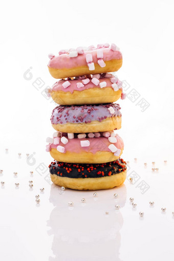 拍摄甜蜜的甜甜圈堆放前形式塔美味的美味的甜蜜的甜甜圈色彩斑斓的洒白色背景