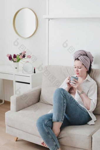好早....微笑年轻的女人喝咖啡舒适的房间首页放松情绪保持首页饮料茶生活方式