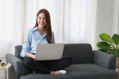 女人享受内容流媒体电影社会媒体应用程序移动PC电脑坐着沙发首页
