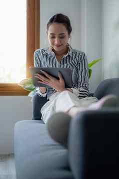 女人享受内容社会媒体应用程序数字平板电脑躺沙发首页