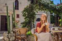 年轻的女人旅游饮料咖啡小镇布德瓦旅行黑山共和国概念