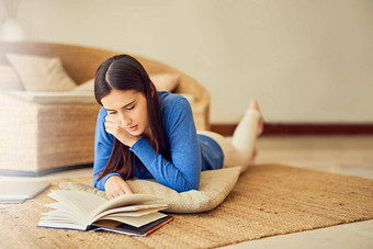 全神贯注<strong>叙述</strong>拍摄年轻的女人阅读书休息室地板上首页