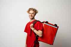交付男人。员工男人。红色的T恤统一的工作服工作经销商快递持有红色的热食物袋背包孤立的白色背景服务概念