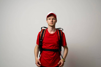 年轻的快递红色的统一的t恤红色的食物热袋肩膀站孤立的白色背景工作室食物交付服务