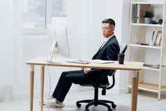 亚洲男人。坐着桌子上前面电脑情绪工作空间