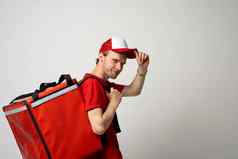 一边视图交付员工男人。红色的帽t恤统一的热食物袋背包工作快递服务