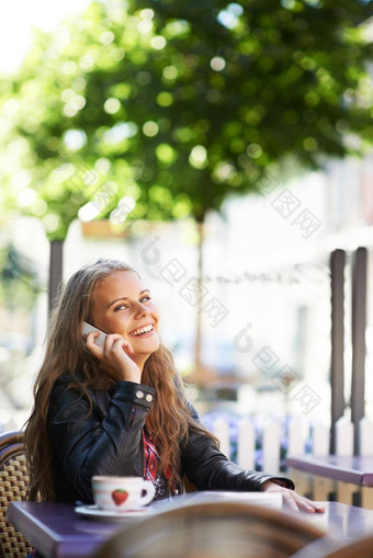 位美丽的青少年会说话的手机坐着小酒馆