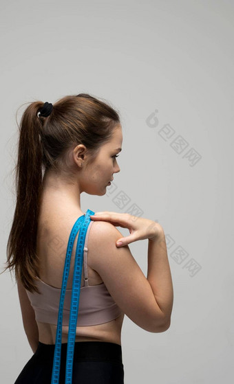 回来年轻的美丽的运动浅黑肤色的女人女人运动服装装健身培训蓝色的测量磁带肩膀重量损失饮食概念