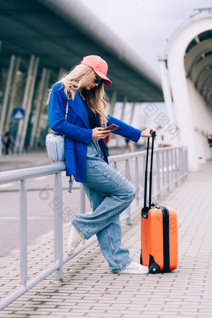 肖像旅行者女人站橙色手提箱机场年轻的时尚图片-包图网企业站