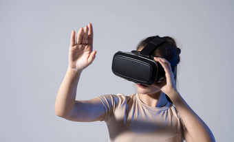 关闭年轻的女人站工作室穿眼镜刷滚动手空气虚拟现实技术