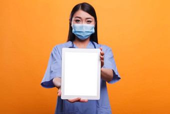 医疗保健诊所亚洲护士穿病毒保护口罩听诊器