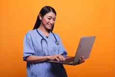 快乐微笑亚洲医疗保健诊所护士穿听诊器现代移动PC