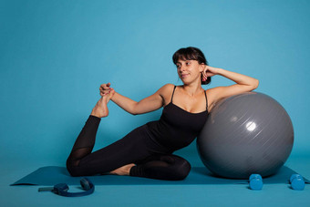 肖像运动员女人坐着<strong>瑜伽</strong>席倾斜<strong>瑜伽健身球</strong>