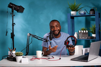 视频博客坐着桌子上工作室移动PC视频记录设置回顾一对音频耳机