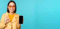 微笑朝鲜文女人显示移动电话应用程序接口智能手机应用程序推荐手机站蓝色的背景