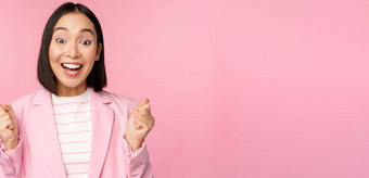 热情的女售货员亚洲企业女人实现目标庆祝并喜乐微笑站粉红色的背景