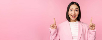 热情的企业工人亚洲业务女人指出手指微笑显示广告标志站粉红色的背景