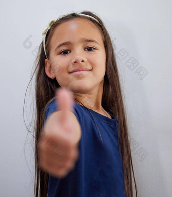 鼓励拍摄可爱的女孩显示拇指摆姿势墙