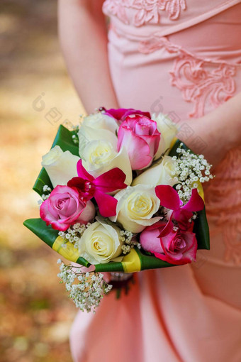 年轻的高加索人女人粉红色的花边衣服持有花束