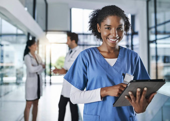 病人记录数字化拍摄年轻的医生数字平板电脑医院的同事们背景