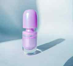 瓶紫色的指甲波兰的白色表面影子时尚美概念