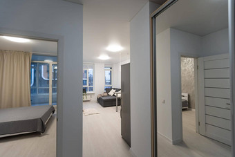 小白色公寓走廊白色门黑色的通过处理木地板上卧室门开放