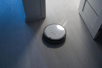 机器人真空更清洁的层压板木地板上卧室