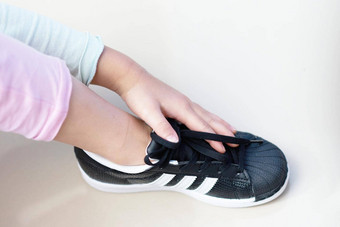 曼谷泰国7月孩子手触摸黑色的运动鞋鞋子品牌阿迪达斯