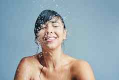 惊人的振兴水拍摄年轻的女人让人耳目一新淋浴蓝色的背景