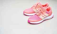 粉红色的体育运动鞋子前视图地板上
