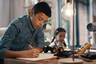 家庭作业游戏时间拍摄英俊的年轻的男孩家庭作业机器人首页年轻的妹妹背景