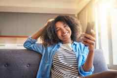 时间什么社会媒体拍摄快乐的年轻的女人浏览手机坐着沙发上首页一天
